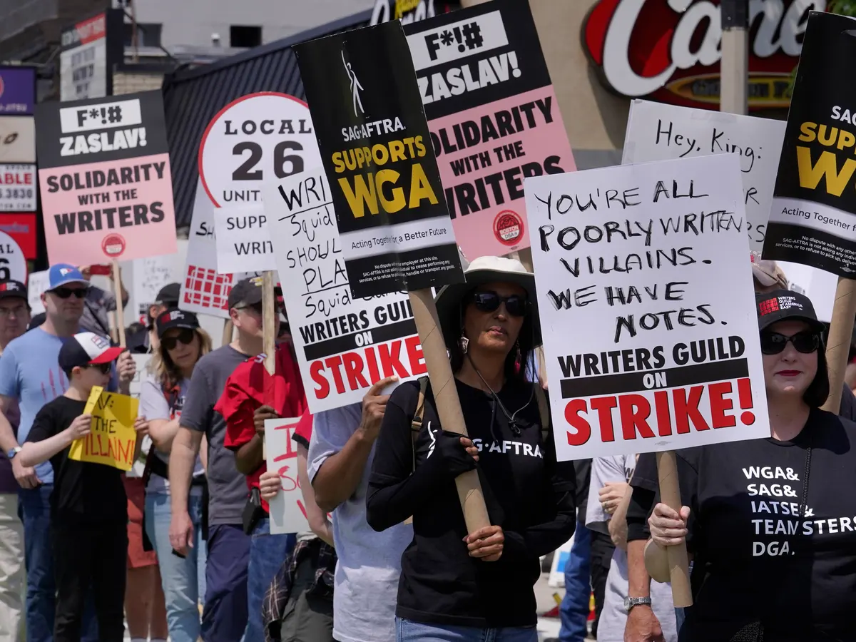 "Protestantes en apoyo a la huelga de guionistas de Hollywood se manifiestan en la entrada de la Universidad de Boston. Fotografía: Steven Senne/AP"